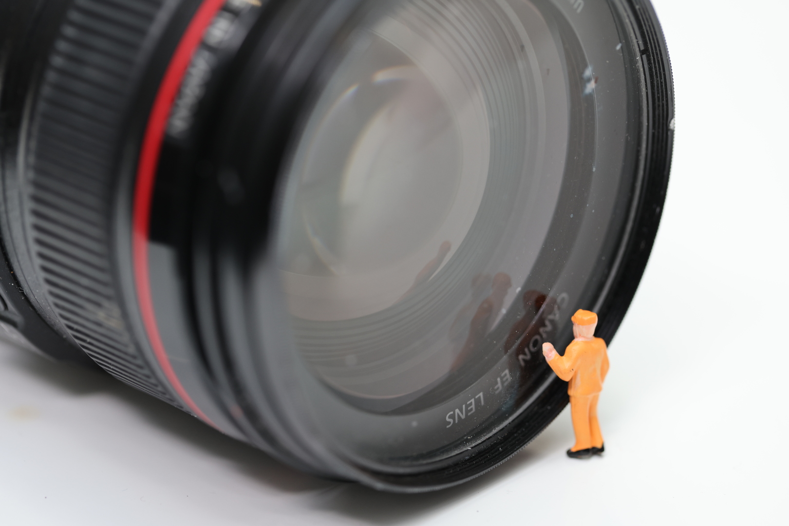Macro image of Canon lens with plastic figurine in front of it